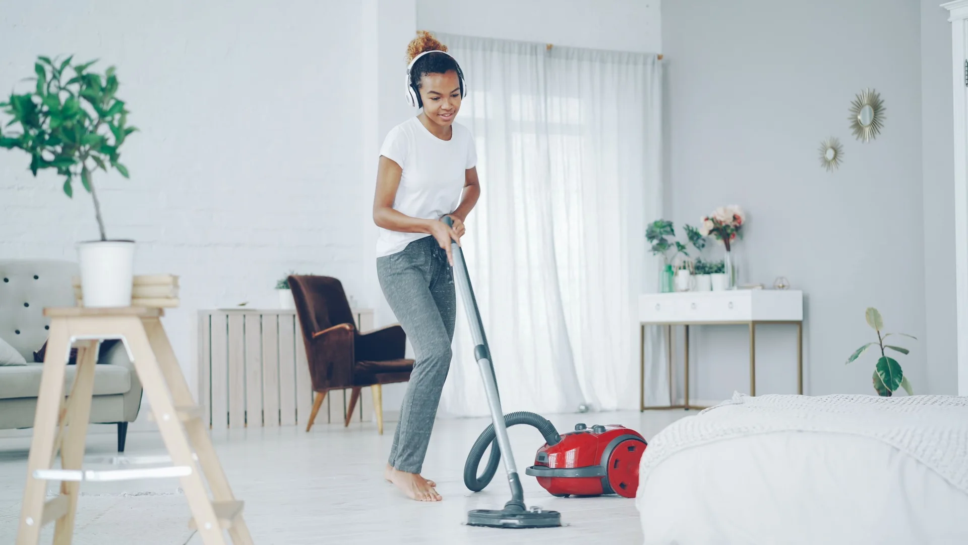 A person vacuuming a bright, clean living room